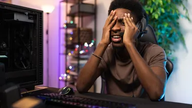 Shocked young black man looking at his computer screen